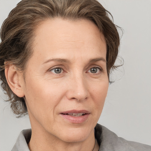 Joyful white adult female with medium  brown hair and grey eyes