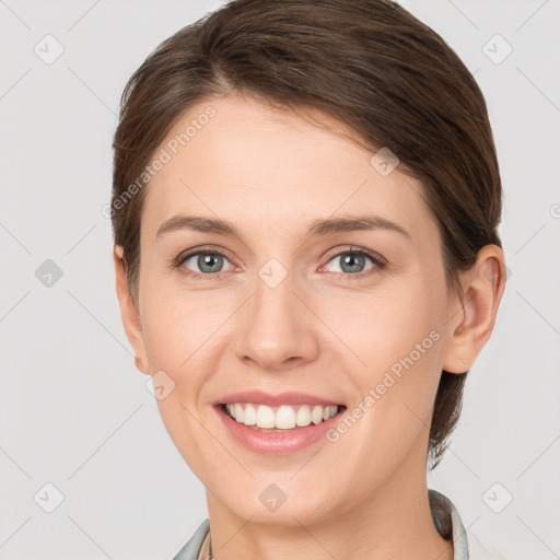 Joyful white young-adult female with short  brown hair and grey eyes