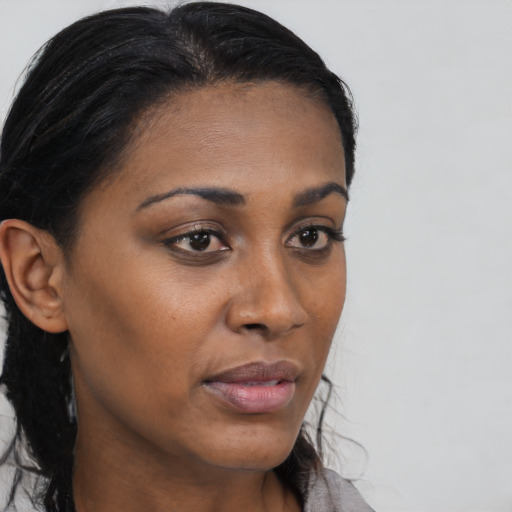Joyful black young-adult female with long  brown hair and brown eyes
