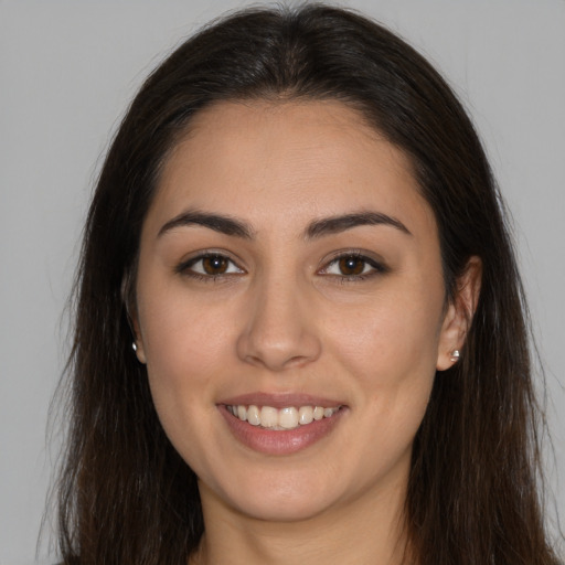 Joyful white young-adult female with long  brown hair and brown eyes