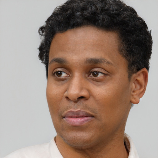 Joyful black adult male with short  black hair and brown eyes