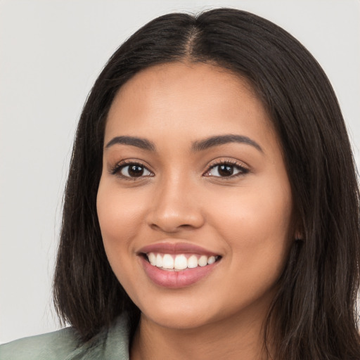 Joyful latino young-adult female with long  brown hair and brown eyes