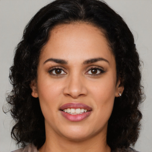 Joyful latino young-adult female with long  brown hair and brown eyes