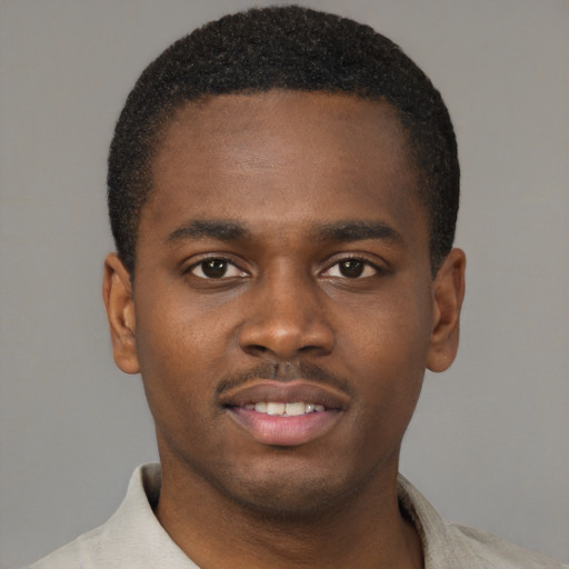 Joyful black young-adult male with short  brown hair and brown eyes