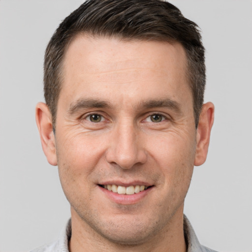 Joyful white adult male with short  brown hair and brown eyes