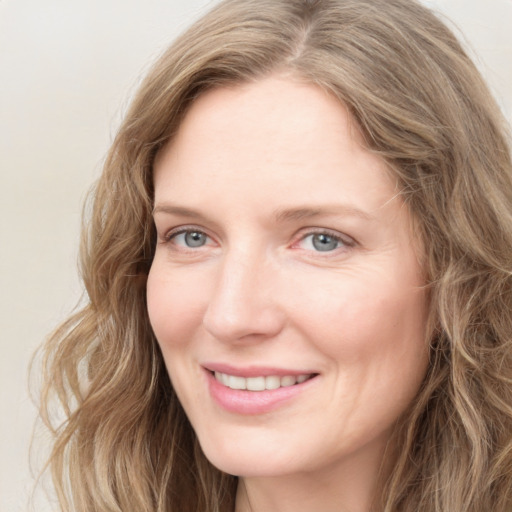 Joyful white young-adult female with long  brown hair and blue eyes