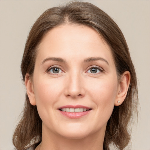 Joyful white young-adult female with medium  brown hair and grey eyes