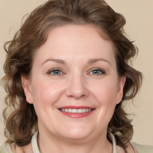 Joyful white adult female with medium  brown hair and blue eyes