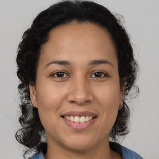 Joyful latino young-adult female with medium  brown hair and brown eyes