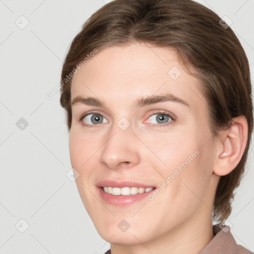 Joyful white young-adult female with medium  brown hair and grey eyes