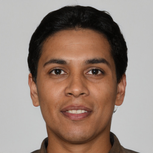Joyful latino young-adult male with short  black hair and brown eyes