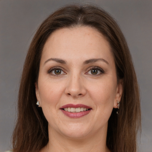 Joyful white adult female with long  brown hair and brown eyes