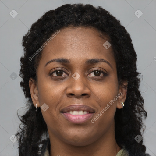 Joyful black young-adult female with long  brown hair and brown eyes