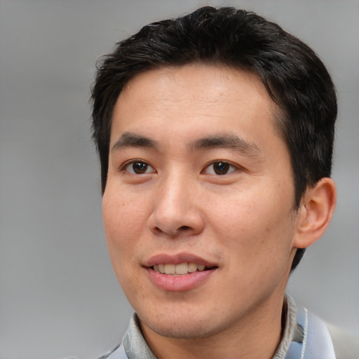 Joyful asian young-adult male with short  brown hair and brown eyes