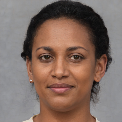 Joyful black adult female with short  brown hair and brown eyes