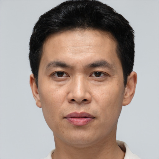 Joyful asian adult male with short  black hair and brown eyes