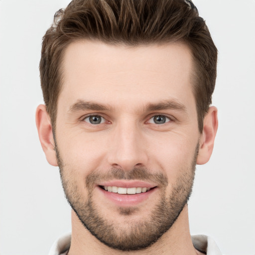 Joyful white young-adult male with short  brown hair and grey eyes