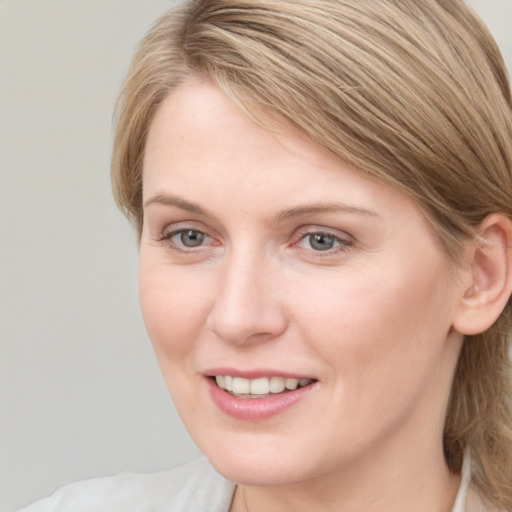 Joyful white young-adult female with medium  brown hair and blue eyes