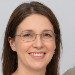 Joyful white adult female with long  brown hair and grey eyes