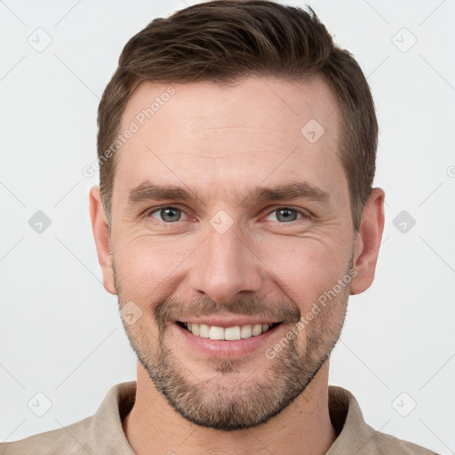 Joyful white young-adult male with short  brown hair and grey eyes