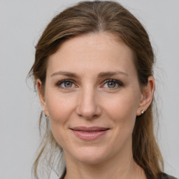 Joyful white adult female with long  brown hair and grey eyes