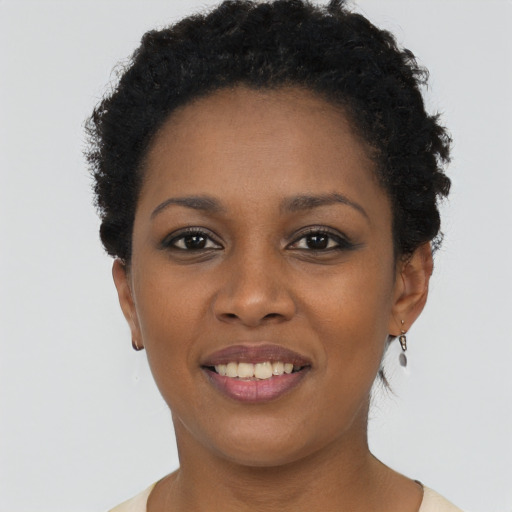 Joyful black young-adult female with short  brown hair and brown eyes