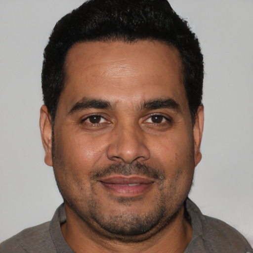 Joyful black adult male with short  black hair and brown eyes