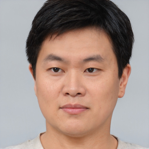 Joyful asian young-adult male with short  black hair and brown eyes