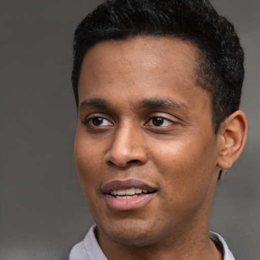 Joyful black young-adult male with short  black hair and brown eyes