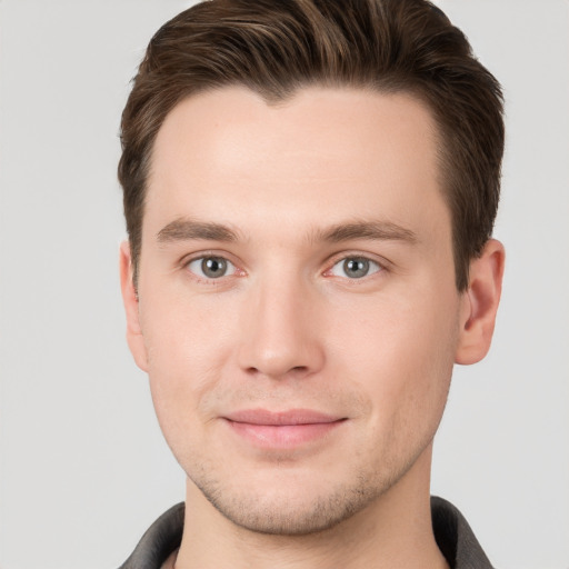 Joyful white young-adult male with short  brown hair and grey eyes