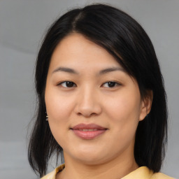 Joyful asian young-adult female with medium  brown hair and brown eyes