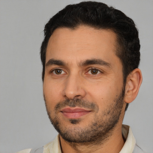 Joyful white young-adult male with short  black hair and brown eyes