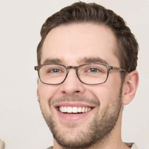 Joyful white young-adult male with short  brown hair and green eyes