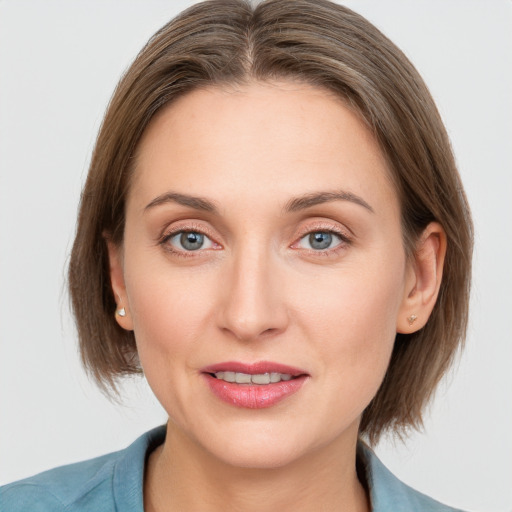 Joyful white young-adult female with medium  brown hair and grey eyes