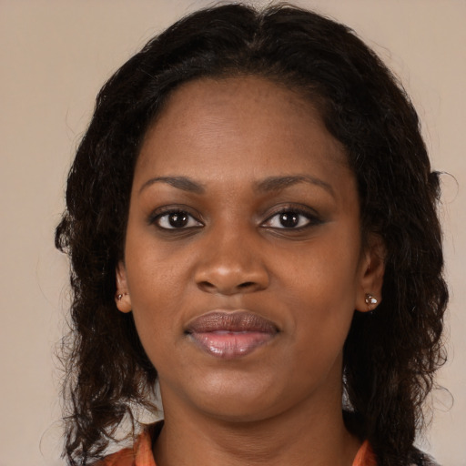 Joyful black young-adult female with long  brown hair and brown eyes