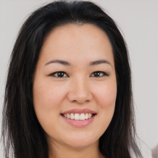 Joyful asian young-adult female with long  brown hair and brown eyes