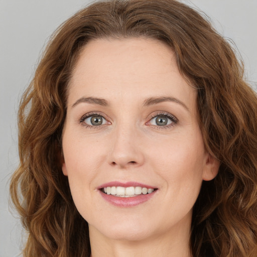 Joyful white young-adult female with long  brown hair and green eyes