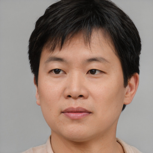 Joyful asian young-adult male with short  brown hair and brown eyes