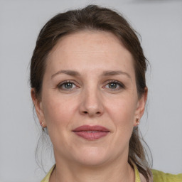 Joyful white adult female with medium  brown hair and grey eyes