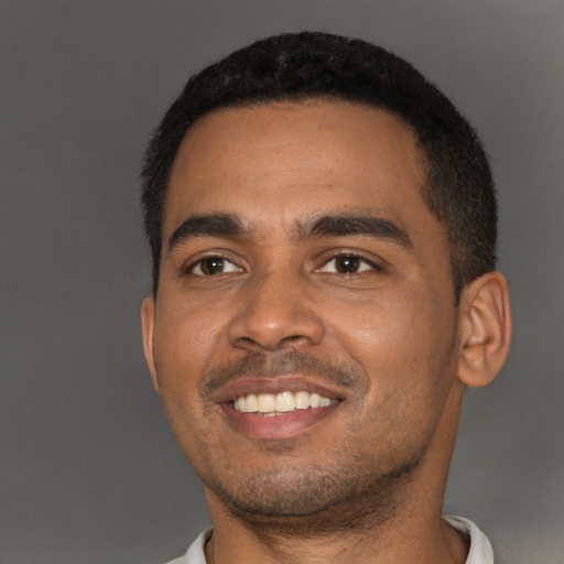 Joyful black young-adult male with short  black hair and brown eyes