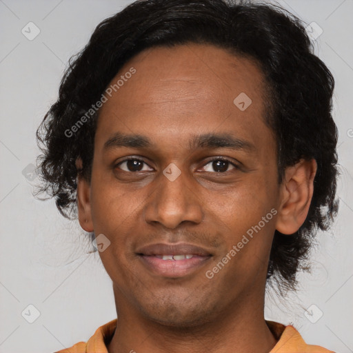 Joyful black young-adult male with short  black hair and brown eyes