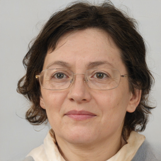 Joyful white adult female with medium  brown hair and blue eyes