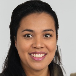 Joyful latino young-adult female with long  brown hair and brown eyes