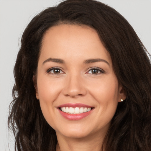 Joyful white young-adult female with long  brown hair and brown eyes