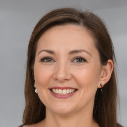 Joyful white adult female with long  brown hair and grey eyes