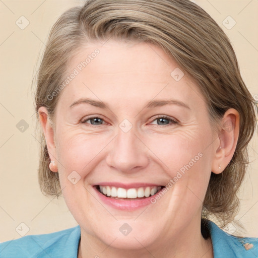 Joyful white adult female with medium  brown hair and blue eyes