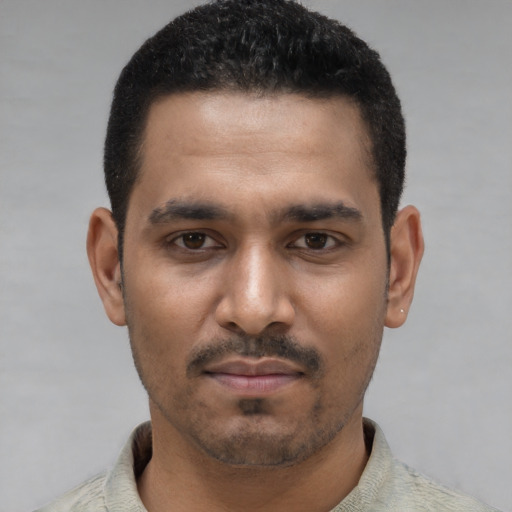 Joyful latino young-adult male with short  black hair and brown eyes