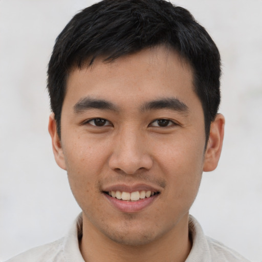 Joyful asian young-adult male with short  black hair and brown eyes