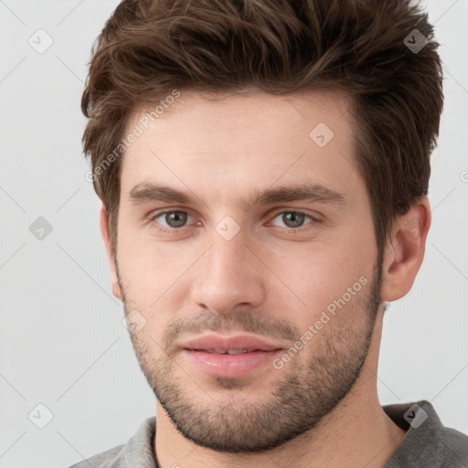 Joyful white young-adult male with short  brown hair and grey eyes