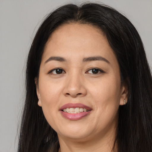 Joyful asian adult female with long  brown hair and brown eyes